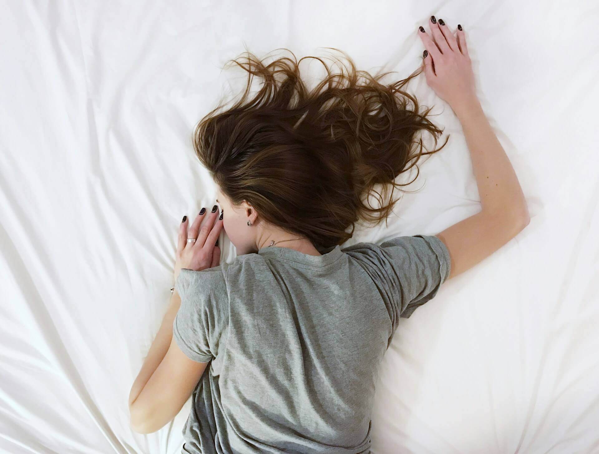 Person sleeping peacefully under soft light (Photo by Vladislav Muslakov/Unsplash)